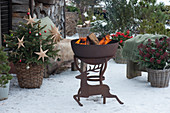 Snowy, Christmassy terrace with fire pit and Christmas tree, a silhouette of a reindeer made of stainless steel