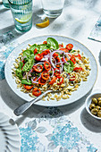 Salat aus Orzo, langsam gerösteten Kirschtomaten, Basilikumöl, Spinat und roten Zwiebeln