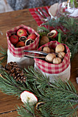 Nüsse und kleine Weihnachtsäpfel in Säckchen