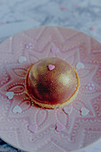 Cupuacu dome tart with ruby chocolate and gold spray