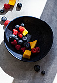 Colourful fruit salad with pieces of mango, raspberries and blueberries