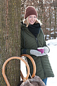 Woman with gloves holding a cup with hot mulled cider wrapped in felt