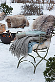 Chair with blankets and fur, firepit in the background