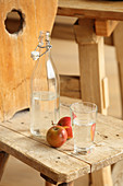 Äpfel und frisches Wasser auf Holzstuhl