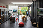 Open plan family home with timber clad walls and wood burning stove