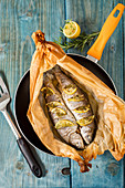 Baked trout in parchment paper with fresh herbs