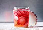 Sweet-and-sour radishes in a screw-top jar