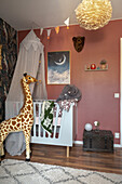 Giraffe figure and crib with a canopy in the room