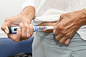 Injecting teriparatide pen into the abdomen