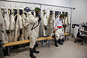 NASA technicans putting on SCAPE suits