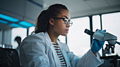 Scientist using microscope in laboratory