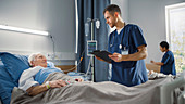 Nurse talking with elderly patient on hospital ward