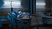 Man wearing oxygen mask in hospital bed