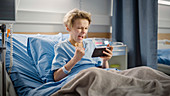 Boy using smartphone in hospital bed
