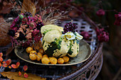 Autumn arrangement of squash, crabapples, rose and scabious