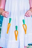 Paper carrot garland held by girl