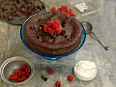 Chocolate Cake on Blue Cake Stand with, Bowl of Raspberries and Whipped Cream
