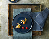 Overhead View of Groundcherries and Raspberries On Blue Plate