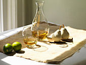 Still life of wine glass, decanter and limes on tabletop