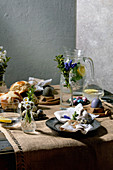 Easter table setting with eggs and hot cross buns
