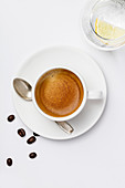 Eine Tasse Kaffee mit Crema auf weißem Untergrund