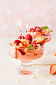 Erdbeer-Himbeer-Sorbet mit weißer Schokolade und brennenden Kerzen