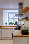 L-shaped fitted kitchen with wooden worktop