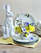 Posy of primulas, violas, lisianthus and waxflowers on Easter table