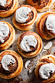 Baked Cinnamon rolls with frosting on a baking tray