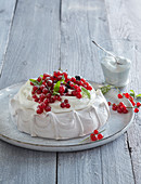 Meringue cake with whipped cream and red currant