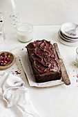 Dunkler Schokoladenkuchen mit Schokoladenglasur und Rosenblüten