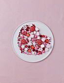 Arrangement zum Valentinstag mit rosa Bonbons und Erdbeeren