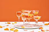 Champagnercocktails in verschiedenen Gläsern mit Rosenblättern