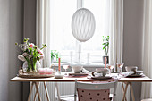 Spring bouquet on table set in pastel pink shades