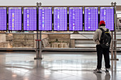 Traveller looking at airport departure boards