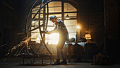 Sculptor using a grinder to make an abstract metal sculpture