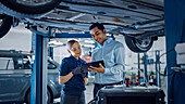 Mechanic and service manager inspecting a car