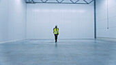 Engineer walking through an empty warehouse