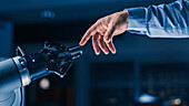 Robotic arm touching a human hand