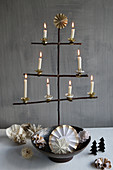 DIY-Weihnachtsschmuck als Tannenbaum vor grauer Wand, dekoriert in Metallschale