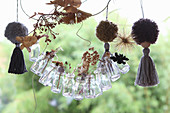 DIY-Girlande aus Mini-Glasflaschen mit getrockneten Gräsern und Pompoms mit Quasten