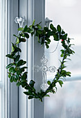 Heart-shaped wreath hanging on window