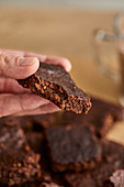 Hand hält Schokoladen-Brownie