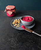 Homemade beetroot hummus with walnuts in a jar as a gift