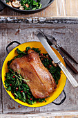 Baked goose breast served with kale