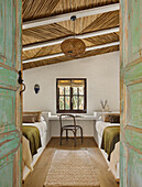 Single beds in the guest room with reed ceiling