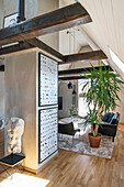 Sculpture of torso against wall, black leather furniture in lounge area and yucca palm in the background