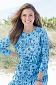 A young woman with long hair wearing a blue patterned dress