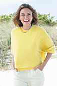 A young woman with long hair wearing a yellow jumper