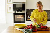 Frau schneidet Gemüse in der Küche